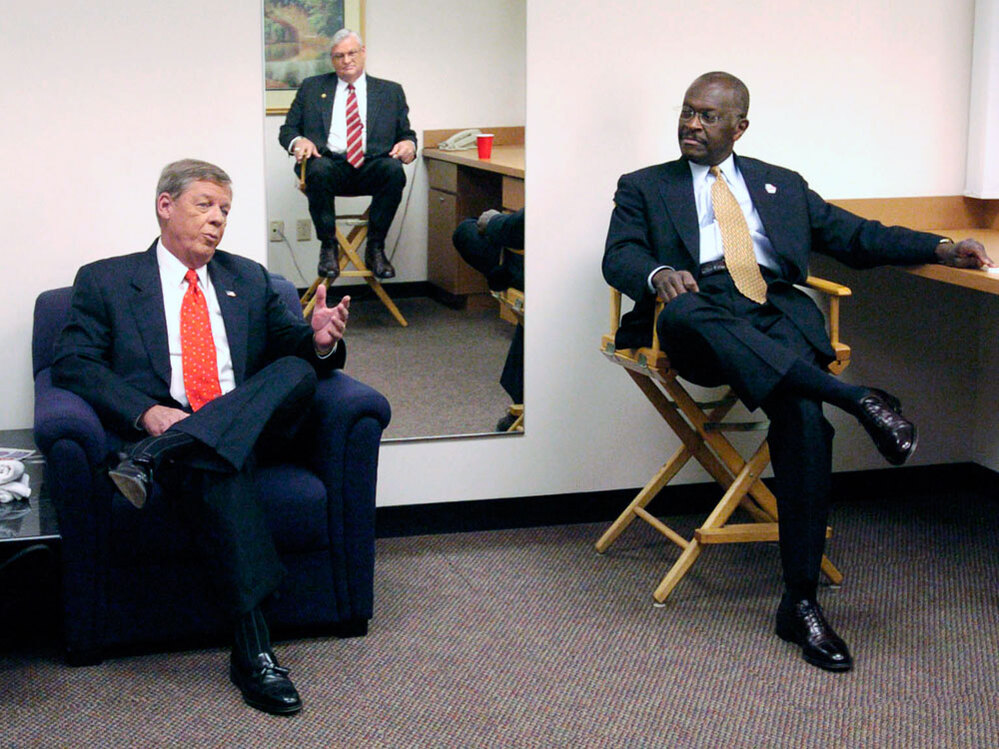 Cain, Johnny Isakson (left) and Mac Collins (reflected in the mirror on the wall) wait before the start of a debate in Atlanta in 2004. The three were running for the U.S. Senate seat then held by Zell Miller.