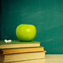 Books in front of a chalkboard. Books in front of a chalkboard.