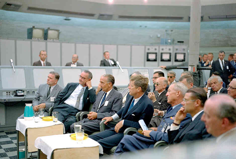 President Kennedy (center) receives a briefing from Maj. Rocco Petrone (not pictured) while on a tour of Cape Canaveral in September 1962. 