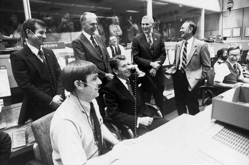 Making an extremely long-distance call, President Ronald Reagan (seated at center) speaks with the crew of the second space shuttle flight from Houston in November 1981.  He jokingly asked if they could stop by Washington en route to their California landing site so he could come along with them. 