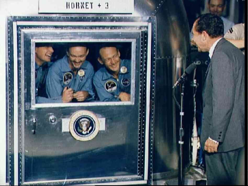 Confined to a quarantine chamber aboard the USS Hornet after returning from the moon, Apollo 11 astronauts Neil Armstrong (from left), Michael Collins and Edwin Aldrin speak to President Richard Nixon on July 24, 1969. 