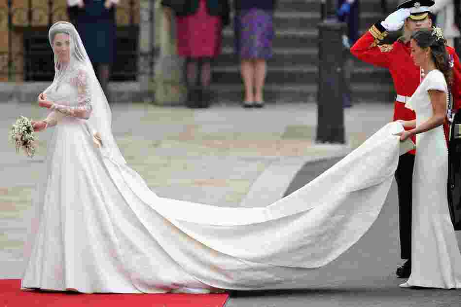 Kate Middleton walks toward Westminster Abby with the help of her sister. Her dress was designed by Sarah Burton for Alexander McQueen. 