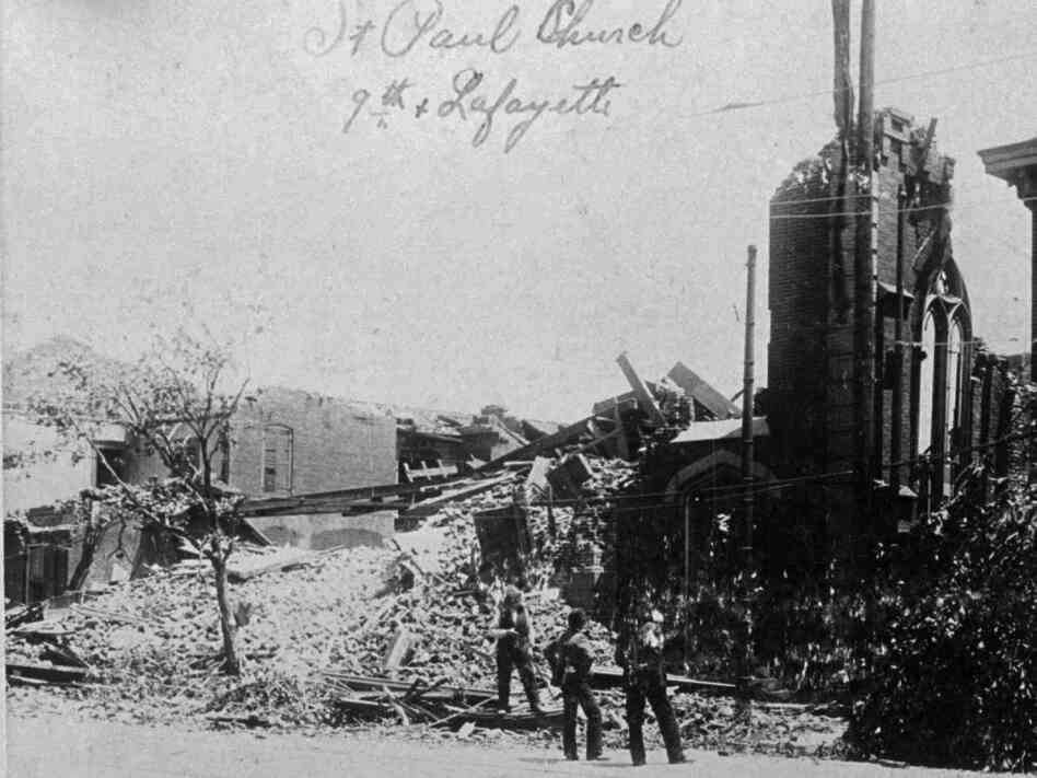 People stand near a demolished church in St. Louis after it was hit by a tornado that killed hundreds of people on May 27, 1896.