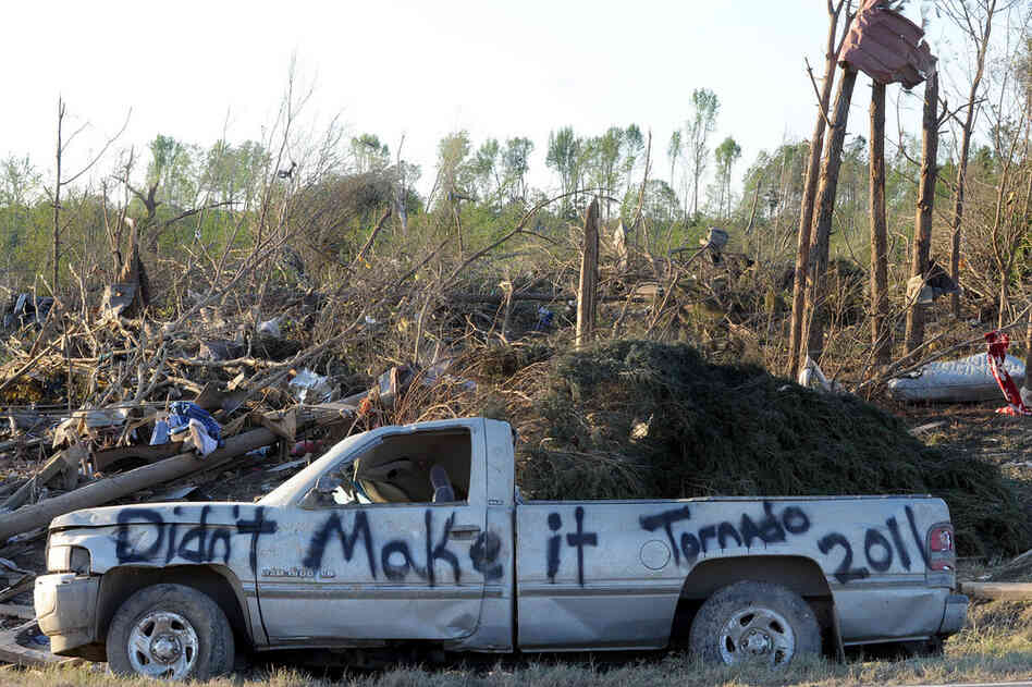 A damaged truck is covered in graffiti in a tornado-ravaged area near Rainsville, Ala., Thursday. At least 32 people died in Dekalb County, when the tornado struck on Wednesday. 