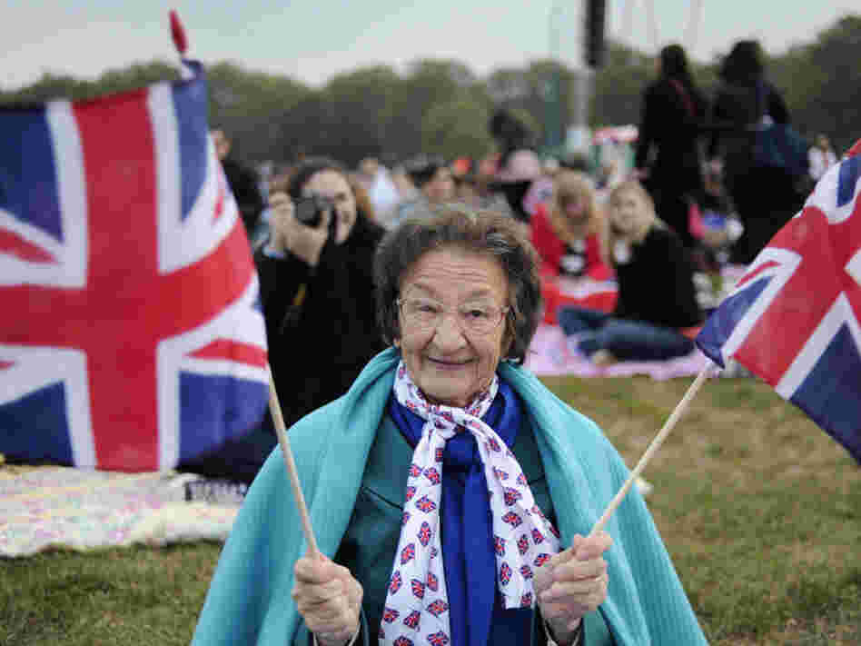 A fan holds British Union Jack flags as people gather to watch the wedding of Britain's Prince William and Kate Middleton on big screens in Hyde Park in central London.