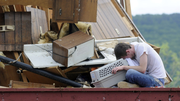Andy Page cries as he sits with his cat, Ellie, placed in a pet carrier, in his storm-demolished apartment in Trenton, Ga., on Thursday. Page has several cats, and Ellie was the last one he was looking for.