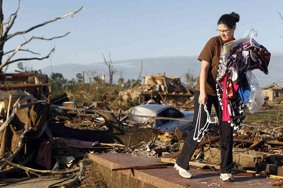 Tiffany Wood carries clothes from her home, a day after a tornado hit Pleasant Grove, Ala. 