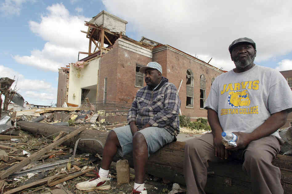 Sal Merritt and Edrich Barnes rest outside the remains of Alberta Baptist Church in Tuscaloosa. 