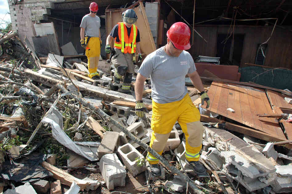 Firefighters search the rubble of a home in the Alberta City section of Tuscaloosa, Ala., on Thursday. 