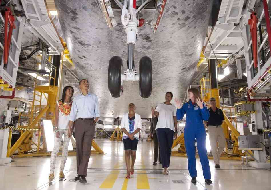 Astronaut Janet Kavandi, director of Flight Crew Operations for Johnson Space Center, leads President Barack Obama, First Lady Michelle Obama and daughters Sasha and Malia, as they view the front landing gear of Space Shuttle Atlantis.