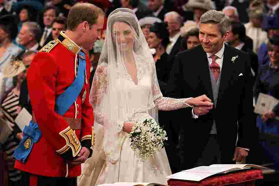 Prince William speaks to Kate Middleton as she holds the hand of her father, Michael, in Westminster Abbey in London on Friday. 