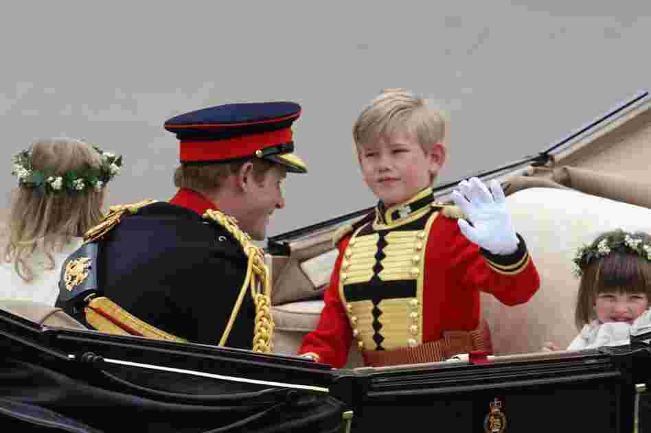 Prince Harry (left), page boy Tom Pettifer and bridesmaid Eliza Lopes (right) travel by carriage to Buckingham Palace. 