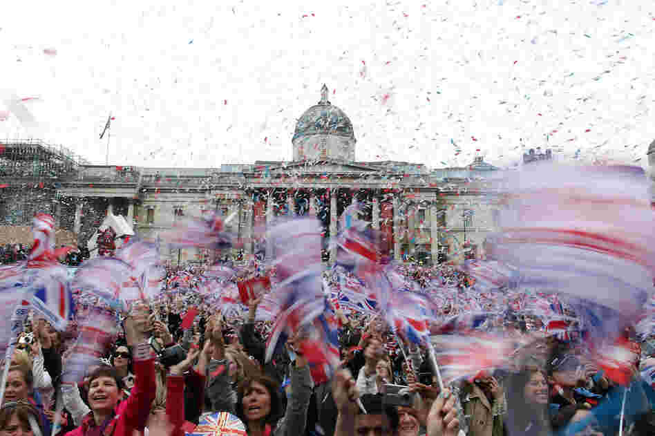Well-wishers wave flags in Trafalgar Square to celebrate the wedding of Prince William and Kate Middleton on Friday. 