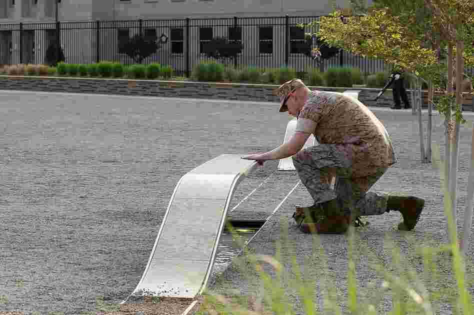 U.S. Marine Staff Sgt. Mark Gamache pays respects to victims of the Sept. 11 terrorists attacks, at the Pentagon Memorial in Arlington, Va. 