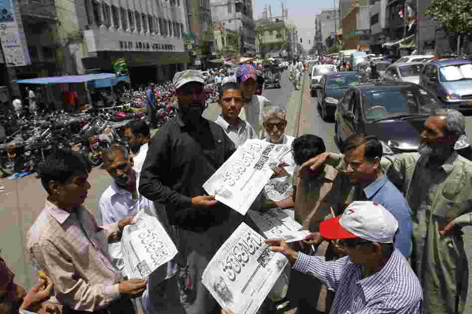 Men in Karachi, Pakistan, buy newspapers reporting the killing of bin Laden. 