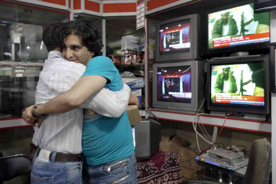 Afghan men hug each other while watching the news of bin Laden's death. Bin Laden was killed in a firefight with U.S. forces at a compound in Abbottabad, Pakistan, early Monday. 