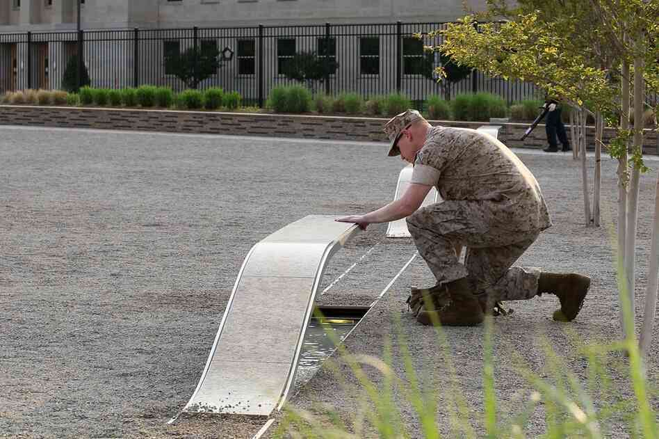 U.S. Marine Staff Sgt. Mark Gamache pays respects to victims of the Sept. 11 terrorists attacks, at the Pentagon Memorial in Arlington, Va. 