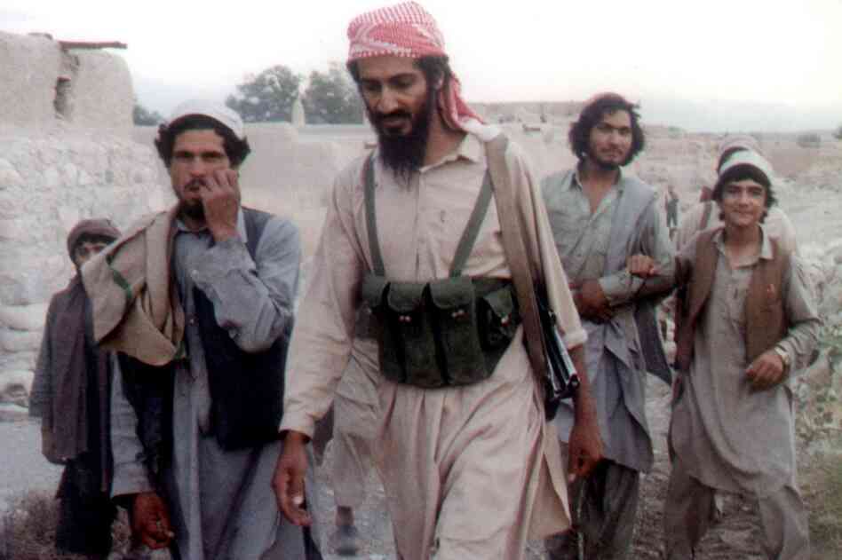 Bin Laden (center) walks with Afghanis in Jalalabad, Afghanistan, in 1989. The news of his death sent the world into celebration and protest. 