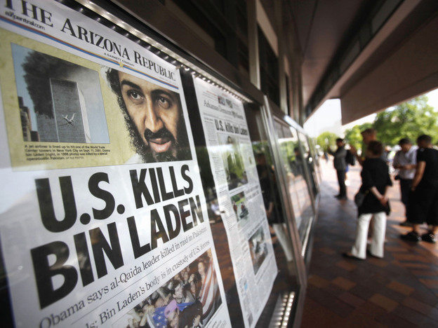People look at a display of newspaper front pages at the Newseum in Washington on Monday. Millions of Americans received the historic news not from Obama's televised news briefing Sunday night, but by text message, email and alerts from Twitter and Facebook, in many instances before the details had been reported by traditional media.