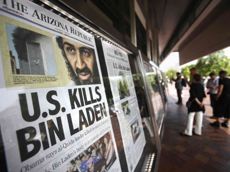 People look at a display of newspaper front pages at the Newseum in Washington on Monday. Millions of Americans received the historic news not from Obama's televised news briefing Sunday night, but by text message, email and alerts from Twitter and Facebook, in many instances before the details had been reported by traditional media.