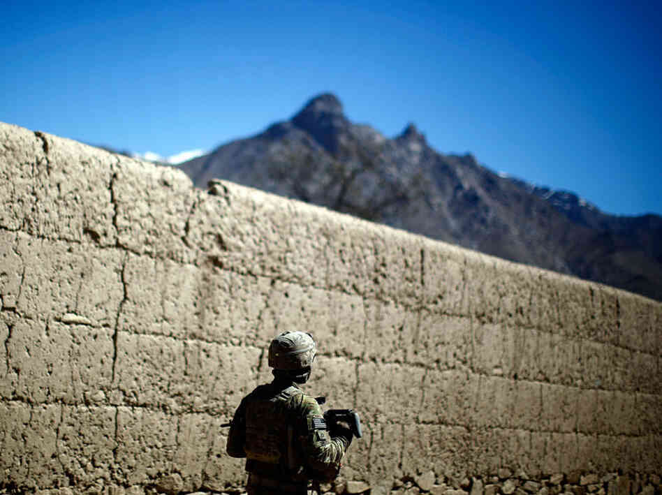 A soldier on patrol in Charkh.  Until Bravo Company took control of both sides of the river, insurgents would often lob homemade hand grenades from behind the mud-brick orchard walls.
