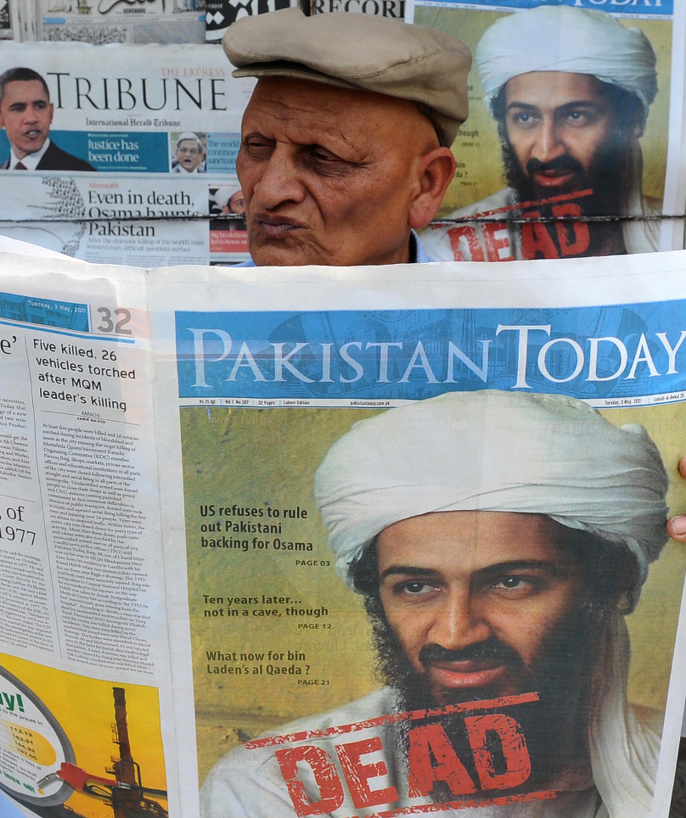 A Pakistani man reads a newspaper with the front page displaying news of the death of Osama bin Laden at a stall in Lahore on May 3, 2011.