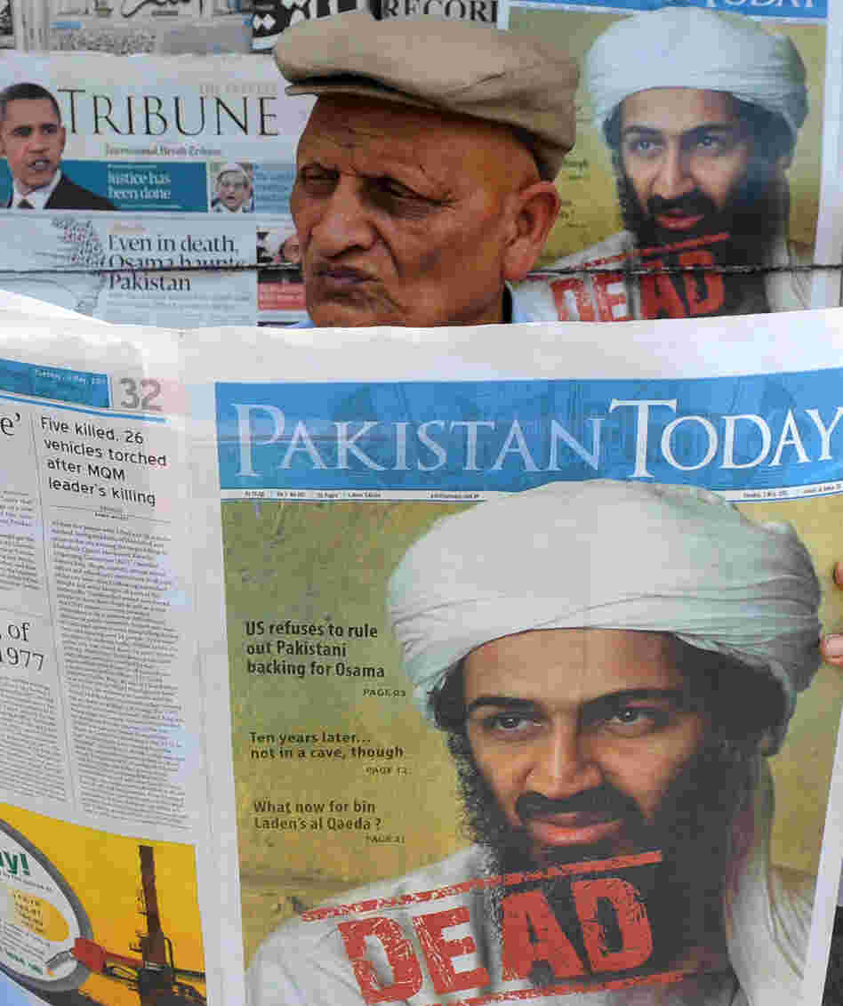A Pakistani man reads a newspaper with the front page displaying news of the death of Osama bin Laden at a stall in Lahore on May 3, 2011.