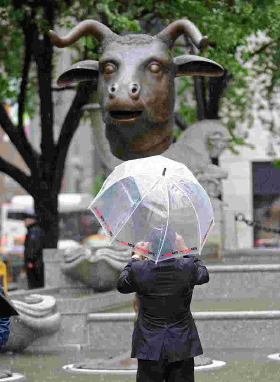 A man photographs "Circle of Animals/Zodiac Heads." Ai's work comprises 12 monumental bronze animal heads representing the 12 animals of the Chinese zodiac. 