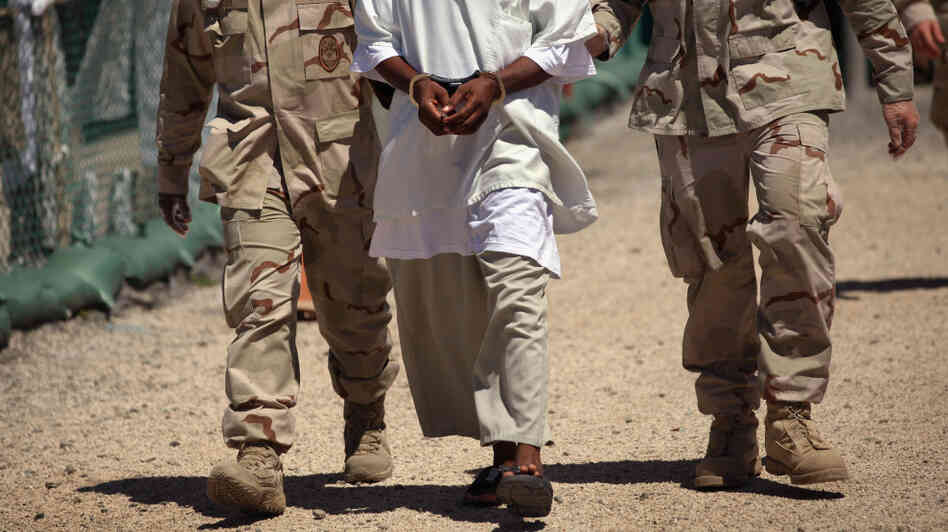 U.S. military guards move a detainee inside the American detention center for "enemy combatants" last year at Guantanamo Bay, Cuba. U.S. military guards move a detainee inside the American detention center for "enemy combatants" last year at Guantanamo Bay, Cuba.
