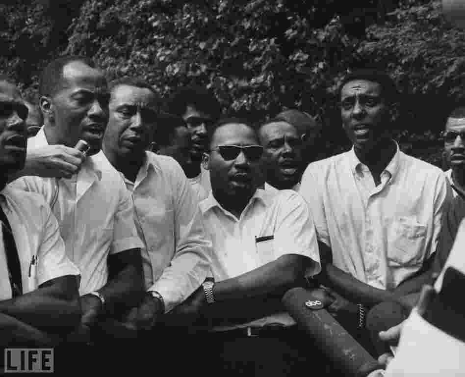 King (center) and his colleagues speak to the press at a voter-registration march from Memphis, Tenn., to Jackson, Miss., in 1966. 