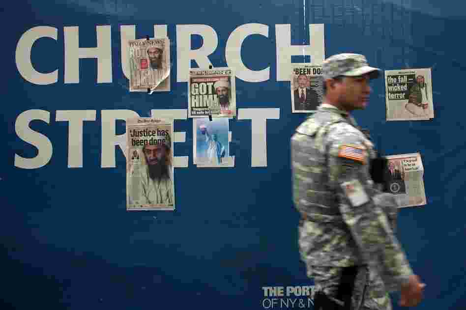 A U.S. soldier walks by newspaper clippings on a wall at ground zero heralding the death of Osama bin Laden, May 2. 