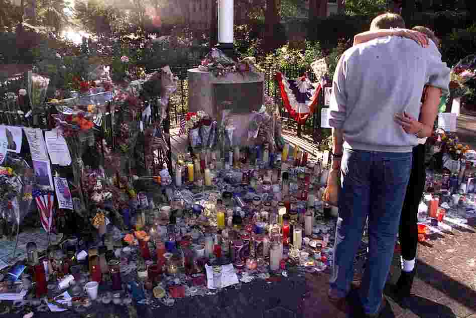 People hug in front of a makeshift memorial for the victims of the World Trade Center attacks, Sept. 18, 2001. 