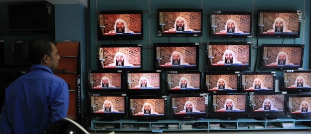 A salesperson in Mumbai, India, watches TV reports on the killing of Osama bin Laden.