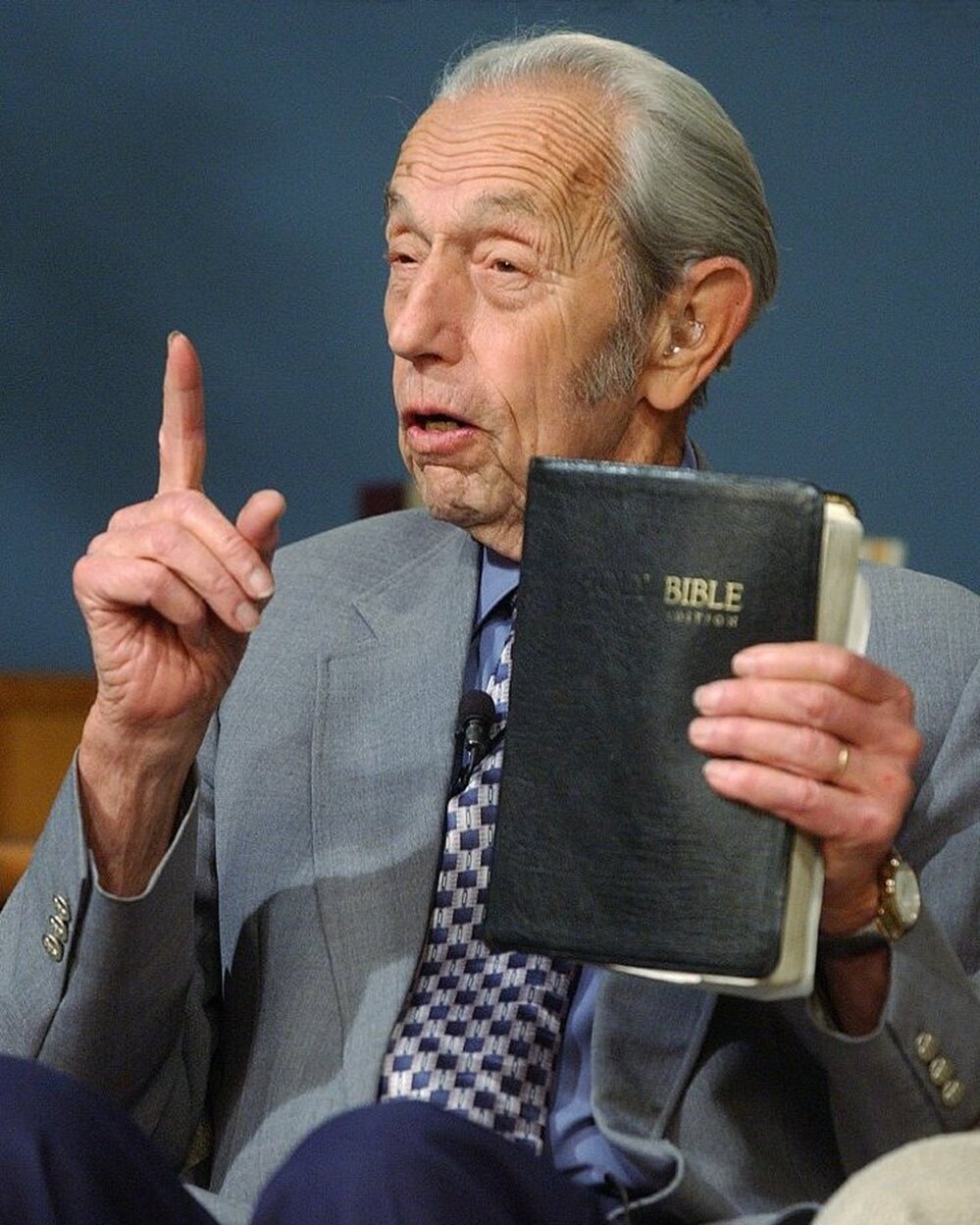 Harold Camping speaks, holding a Bible, during his live television broadcast in 2002.