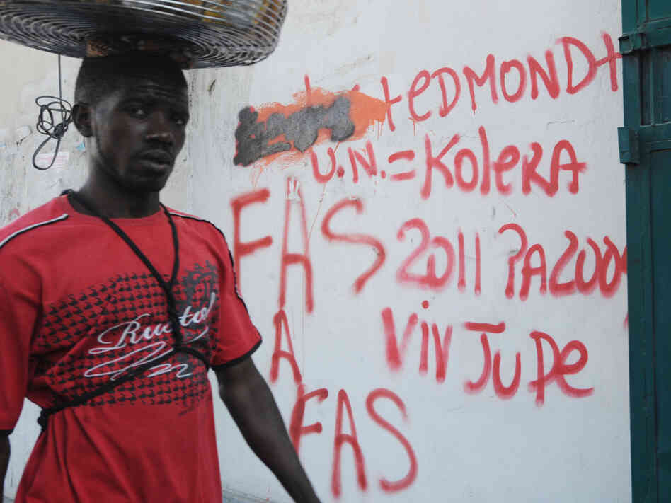 A man walked by a Port-au-Prince wall in February covered with anti-U.N. graffiti that equates the organization with cholera.