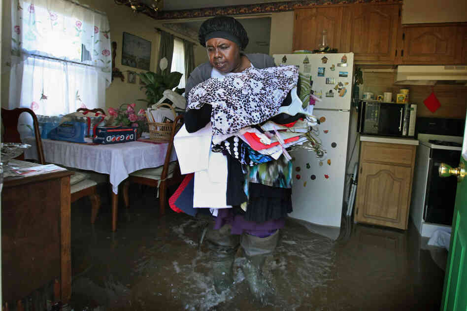 MAY 4: Sally Nance helps her neighbors remove clothes from their home in Tiptonville, Tenn. 