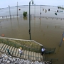 People take a look at Mississippi River floodwaters at the base of Beale Street in Memphis, Tenn.