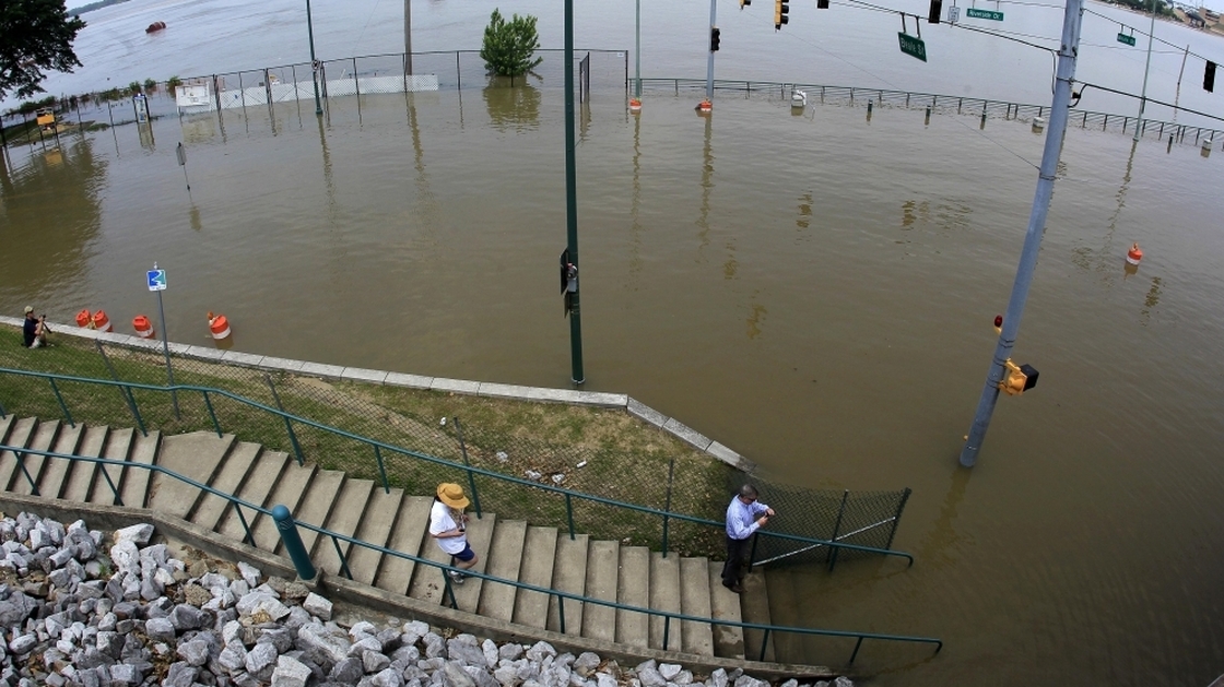 People take a look at Mississippi River floodwaters at the base of Beale Street in Memphis, Tenn.