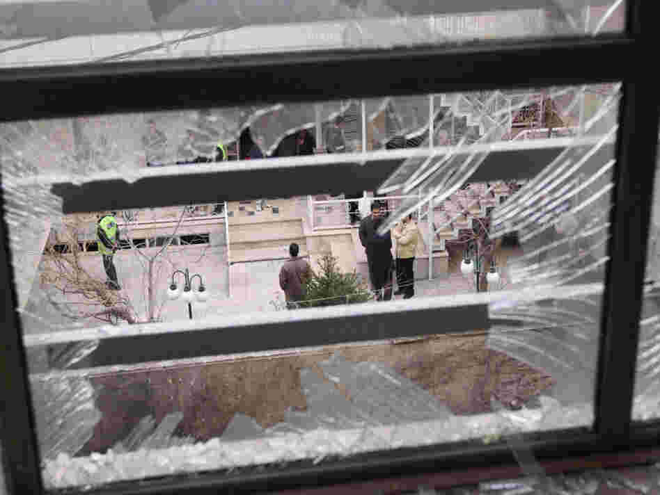 Iranian security agents are seen through a shattered window after Iranian nuclear engineer Massoud Ali Mohammadi was killed outside his Tehran residence when a booby-trapped motorcycle exploded on Jan. 12, 2010.