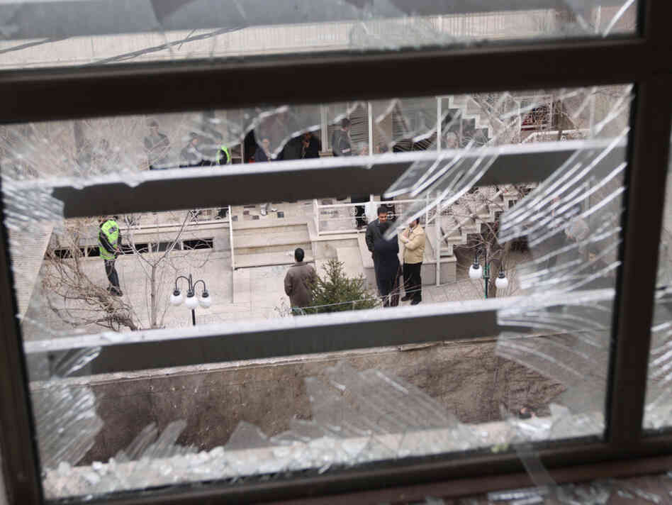 Iranian security agents are seen through a shattered window after Iranian nuclear engineer Massoud Ali Mohammadi was killed outside his Tehran residence when a booby-trapped motorcycle exploded on Jan. 12, 2010.
