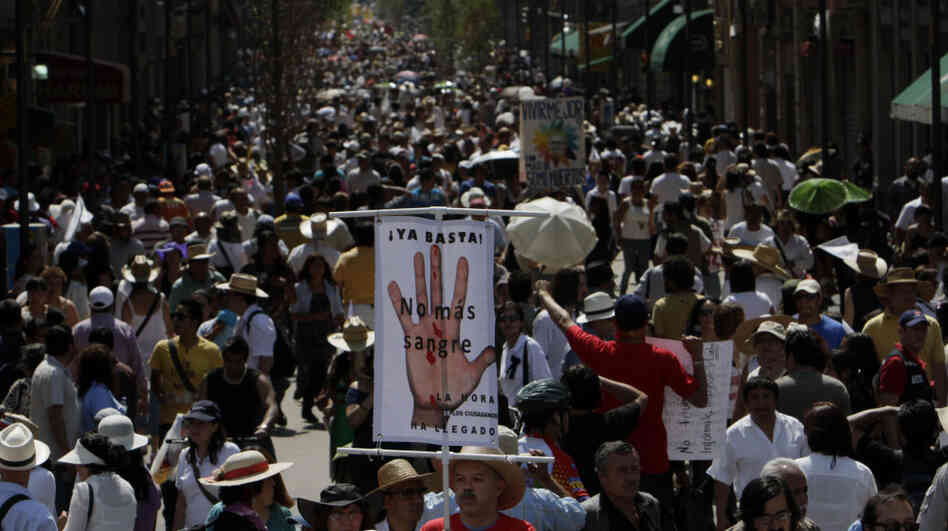 A demonstrator holds a sign reading 'Stop! no more Blood', during a march against gang violence in Mexico City, Sunday, May 8, 2011.