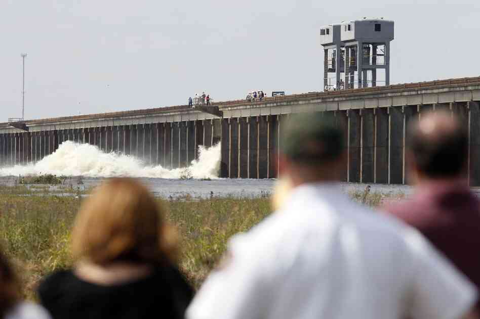 MAY 14: People watch as water diverted from the Mississippi River spills through a bay in Morganza, La. A  floodgate was slowly raised for the first time in nearly four decades, unleashing a torrent of water from the Mississippi River. 