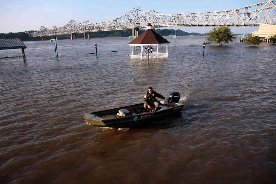 MAY 19: A corrections officer motors through floodwaters of the Mississippi River to pick up prison trustees, who are being used for flood-abatement work in Vidalia. 