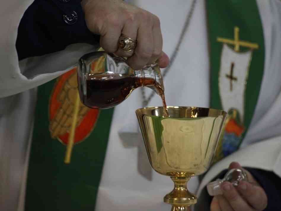 Sept. 2010 file photo: A chaplain pours wine in preparation for communion during a Sunday church service aboard the USS Kearsarge.