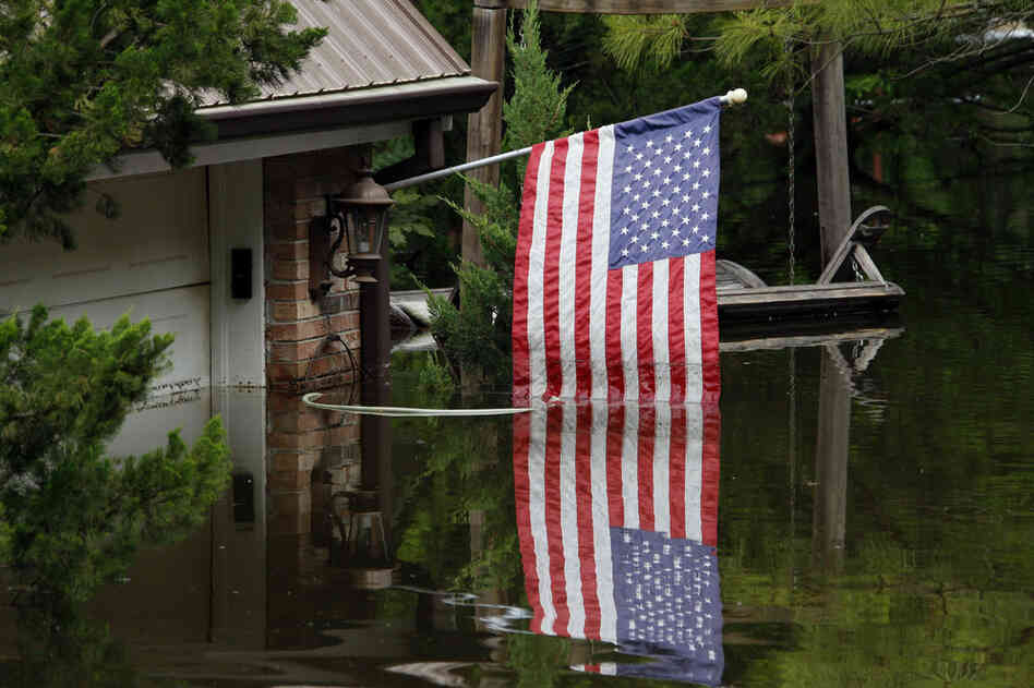 MAY 20: An American flag reflects in Mississippi River floodwaters outside of a home in south Vicksburg, Miss. 