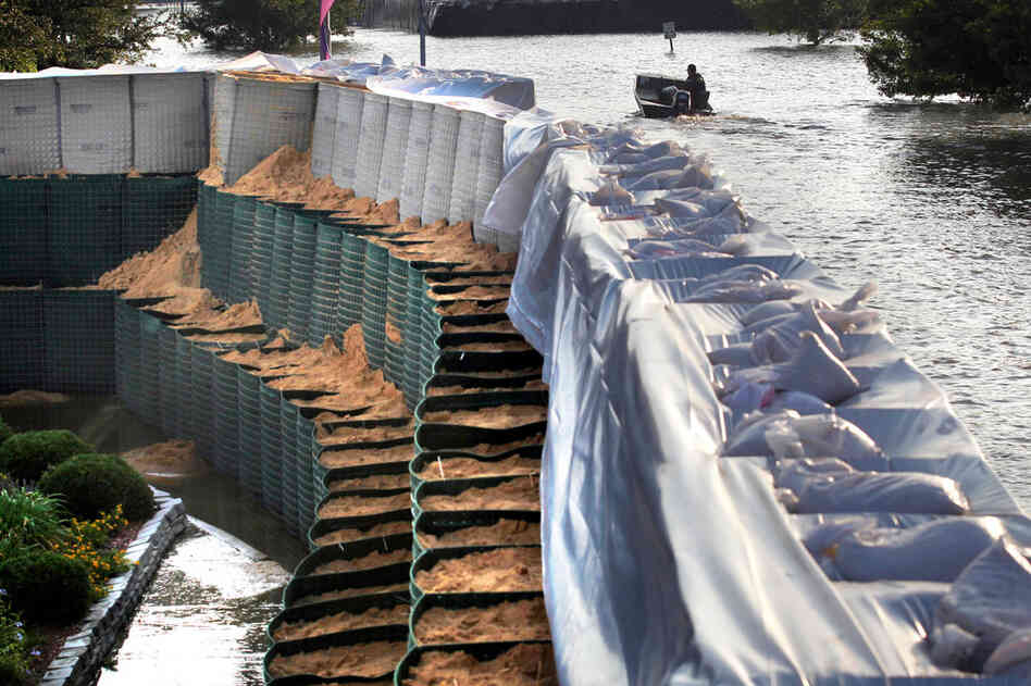 MAY 19: A boat motors through Mississippi River floodwaters past a wall of flood-containment baskets, known as Hesco baskets, that is protecting the Riverside Medical Center in Vidalia, La. 