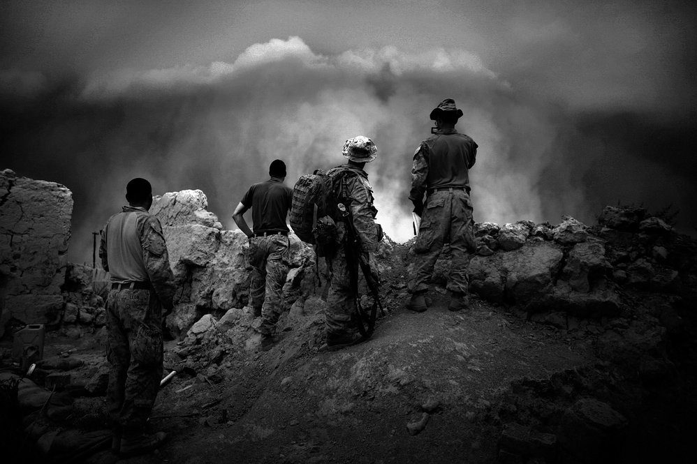Marines watch as a massive dust storm approaches their base. Though fighting slows during poppy harvest, Marines remain on edge, as fighting could erupt at any moment.