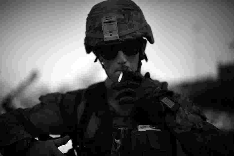 Cpl. Daniel Wheeler lights a cigarette after late afternoon patrol in the scorching heat. Some of the Marines have nicknamed the area "Vietnamistan," after the marshes and junglelike terrain that they navigate daily.