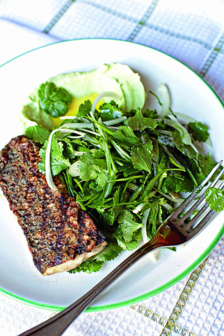 For Cod and Country pairs inventive combinations of fish and fresh vegetables and suggests substitutes for over-harvested fish species. Above, wild striped bass with cilantro-onion salad and yogurt-avocado puree. Click here for this and other recipes.