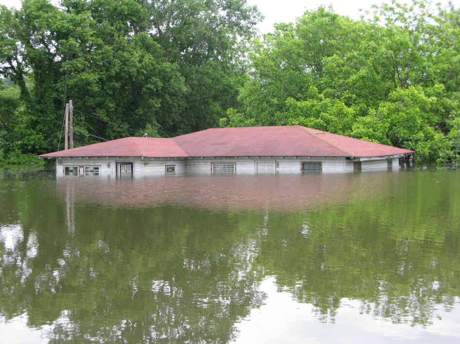 The flooding in Vicksburg has put many houses underwater. Only the roofs are visible on others, like this one.
